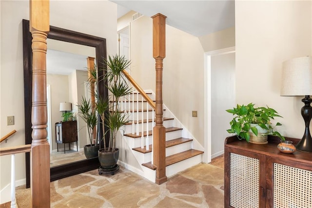 stairway with baseboards, visible vents, and ornate columns