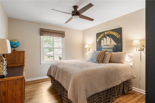 bedroom featuring ceiling fan, baseboards, and wood finished floors