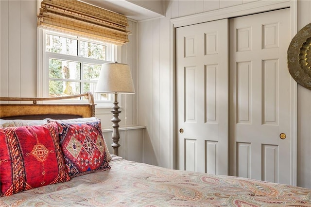 bedroom featuring a closet and wooden walls