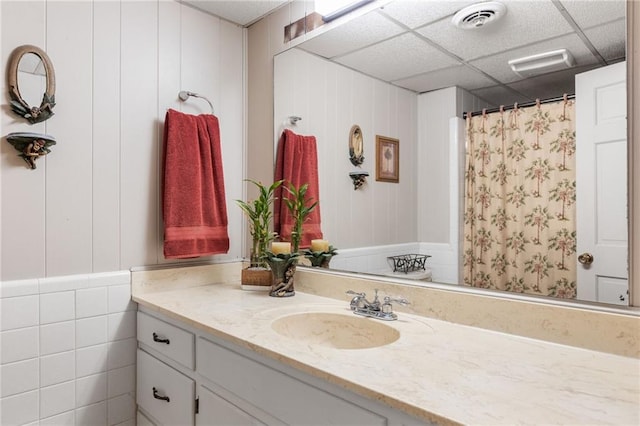 bathroom featuring a shower with shower curtain, visible vents, vanity, and a drop ceiling