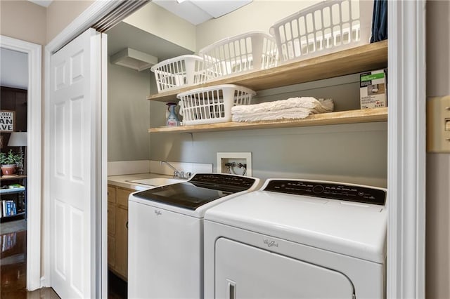 clothes washing area with laundry area, a sink, and washing machine and clothes dryer