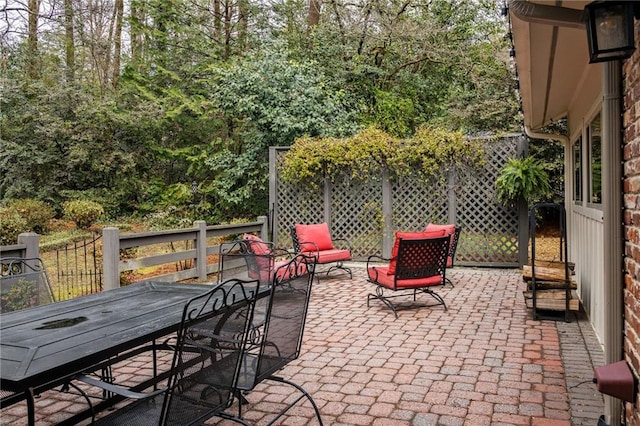 view of patio featuring outdoor dining area and fence