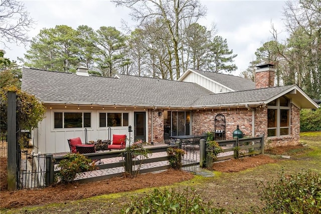 ranch-style home featuring roof with shingles, brick siding, and a chimney