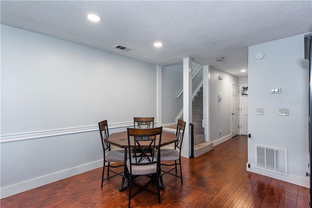 dining area featuring dark wood-type flooring, stairway, baseboards, and visible vents