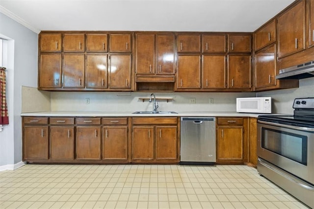 kitchen with sink, ornamental molding, and stainless steel appliances