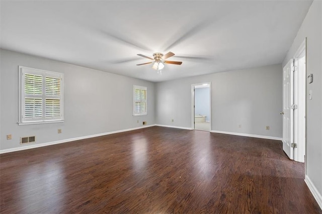 empty room with ceiling fan and dark hardwood / wood-style flooring