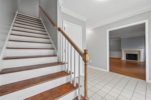 stairs with tile patterned floors and ornamental molding