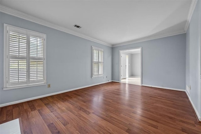 empty room with ornamental molding and hardwood / wood-style floors