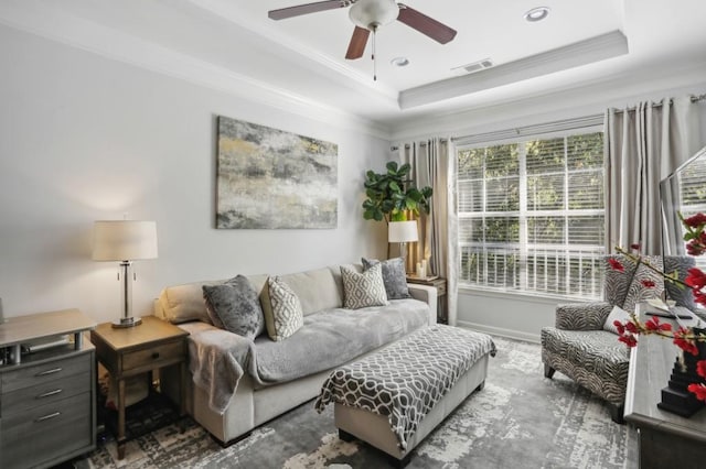 living room featuring crown molding, a raised ceiling, and ceiling fan