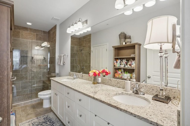 bathroom with vanity, tile patterned floors, toilet, and an enclosed shower