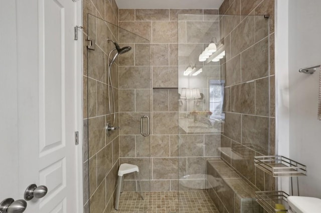 bathroom with a shower with door and toilet