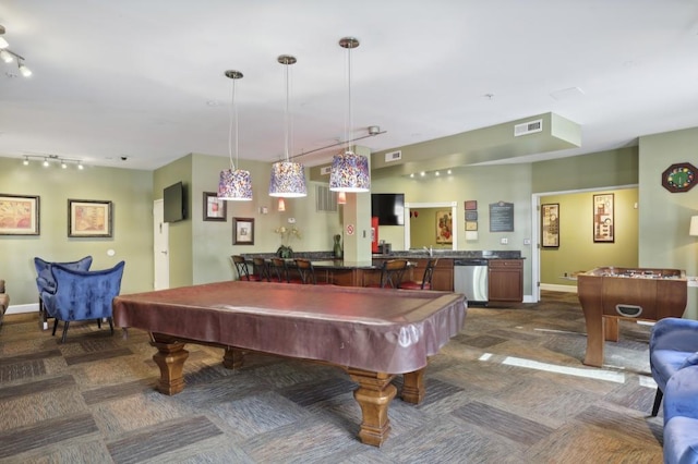 playroom featuring dark carpet, track lighting, and wet bar