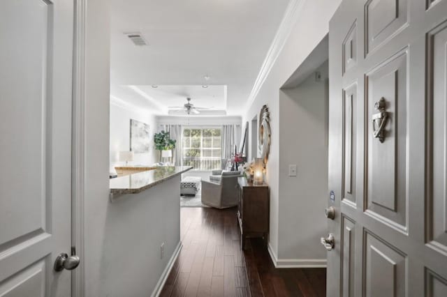 corridor with ornamental molding and dark wood-type flooring