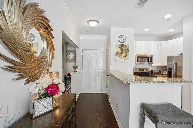 kitchen featuring dark hardwood / wood-style flooring, kitchen peninsula, stainless steel appliances, white cabinets, and light stone counters