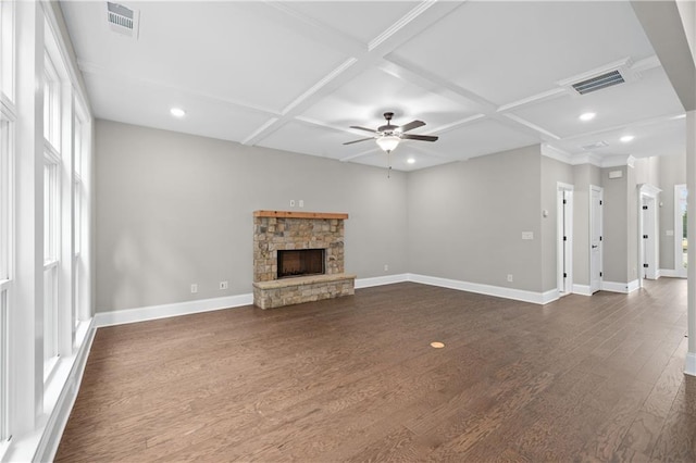 unfurnished living room featuring coffered ceiling, visible vents, a stone fireplace, and dark wood-style floors