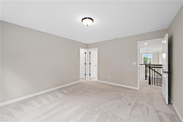 spare room with light carpet and baseboards