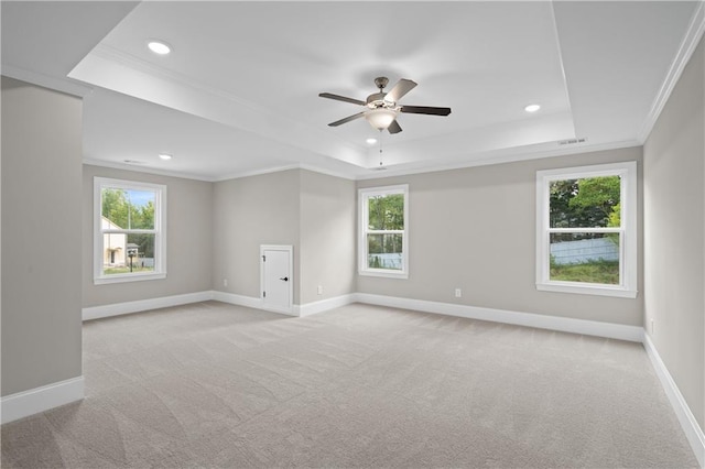 unfurnished room with light carpet, baseboards, a tray ceiling, and ornamental molding