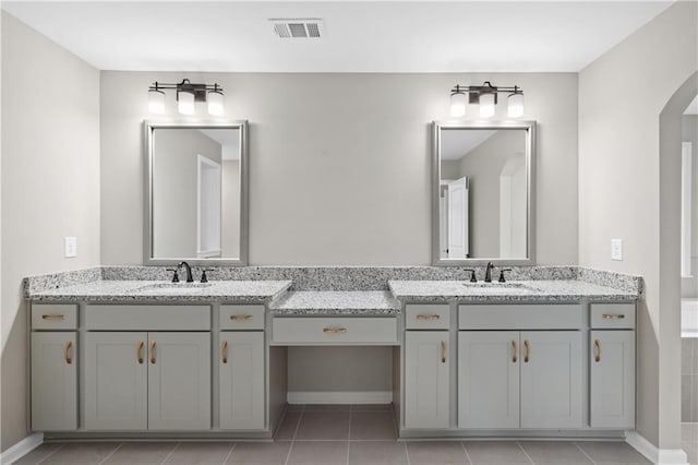 bathroom with double vanity, visible vents, and a sink