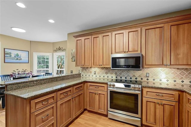 2203 Arbor Hill Rd, Canton, GA 30115 - kitchen featuring stainless steel appliances, stone counters, brown cabinetry, and recessed lighting