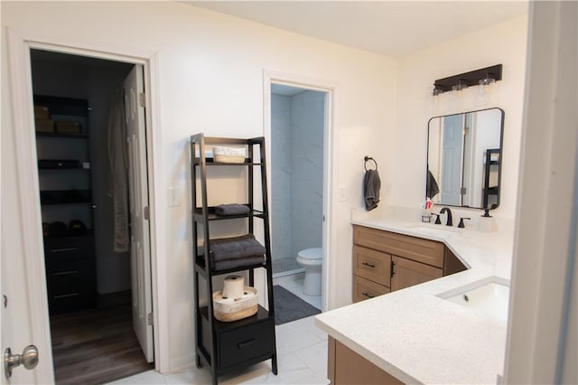 bathroom with marble finish floor, vanity, and toilet