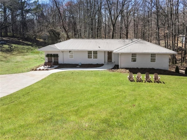 single story home featuring metal roof, a front lawn, and concrete driveway