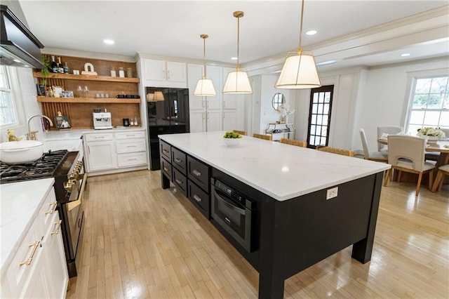 kitchen with open shelves, dark cabinetry, gas range, and white cabinetry