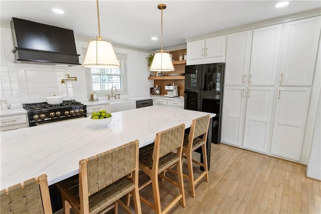 kitchen with custom range hood, a breakfast bar, black appliances, white cabinetry, and open shelves