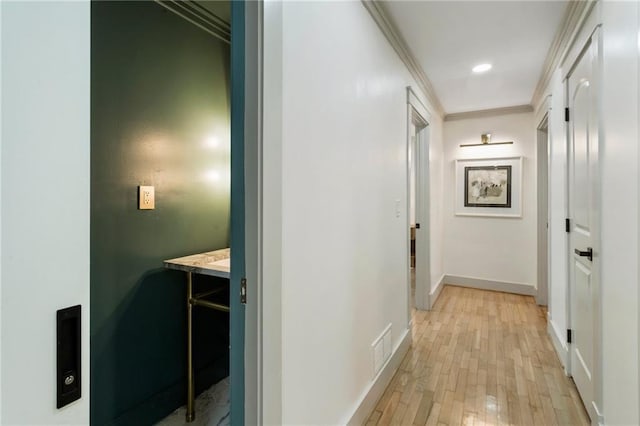 corridor featuring crown molding, recessed lighting, visible vents, light wood-style flooring, and baseboards