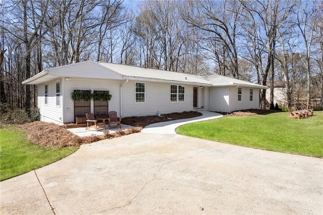 ranch-style house with metal roof and a front lawn