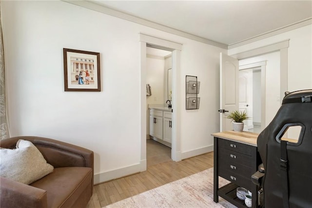 office area featuring ornamental molding, light wood-type flooring, and baseboards