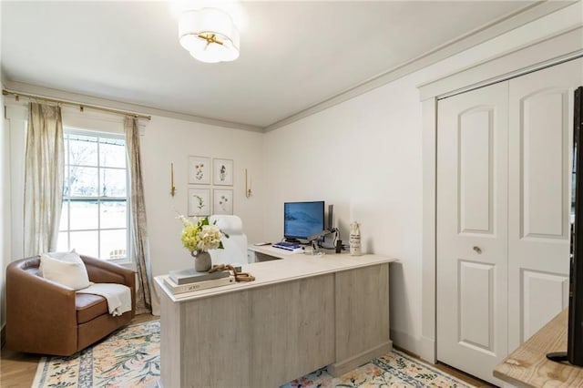 home office featuring baseboards, crown molding, and light wood finished floors