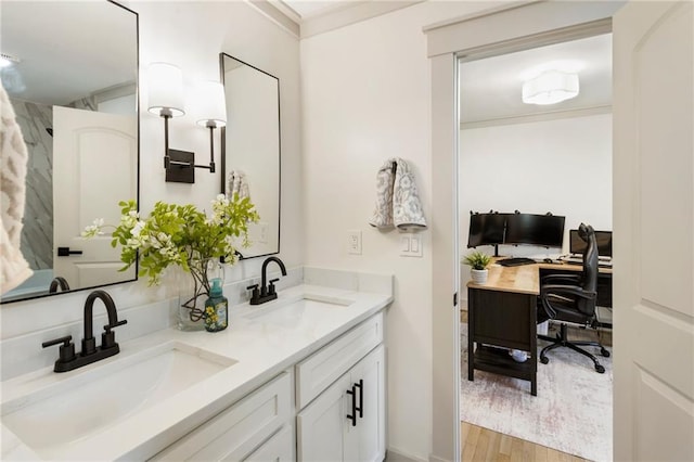 full bathroom with ornamental molding, double vanity, a sink, and wood finished floors