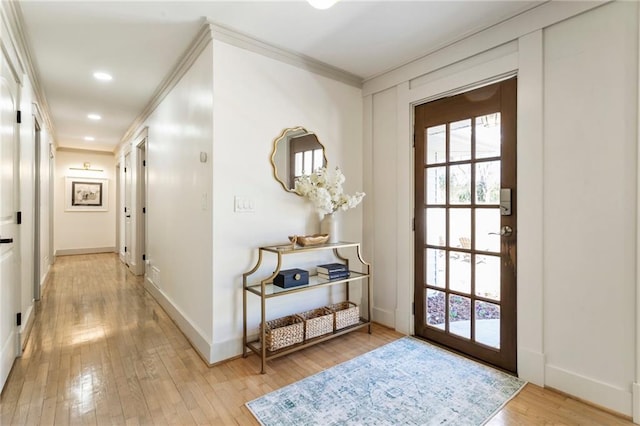 doorway to outside with light wood-style flooring, ornamental molding, baseboards, and recessed lighting