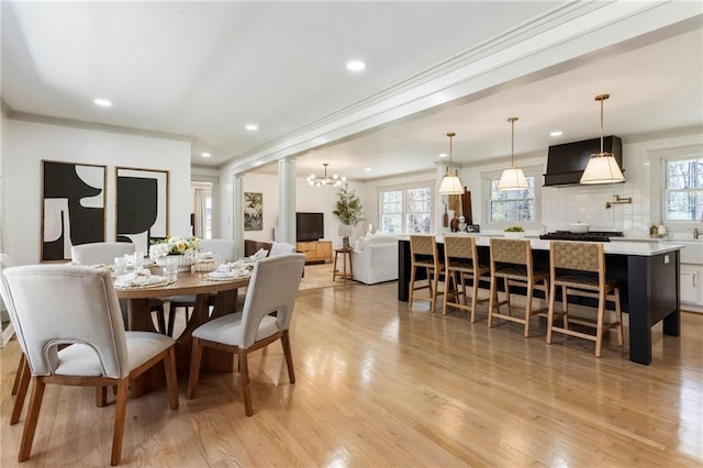 dining area featuring an inviting chandelier, light wood-style flooring, crown molding, and recessed lighting