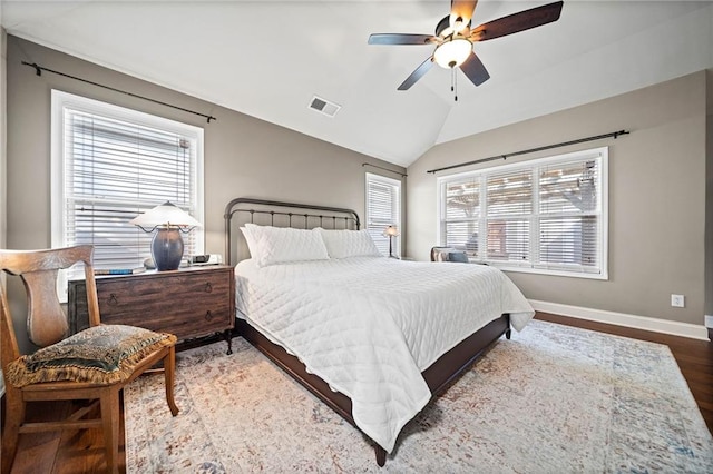 bedroom with hardwood / wood-style flooring, ceiling fan, vaulted ceiling, and multiple windows