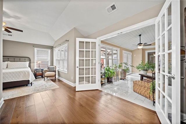 bedroom with access to outside, wood-type flooring, french doors, and vaulted ceiling