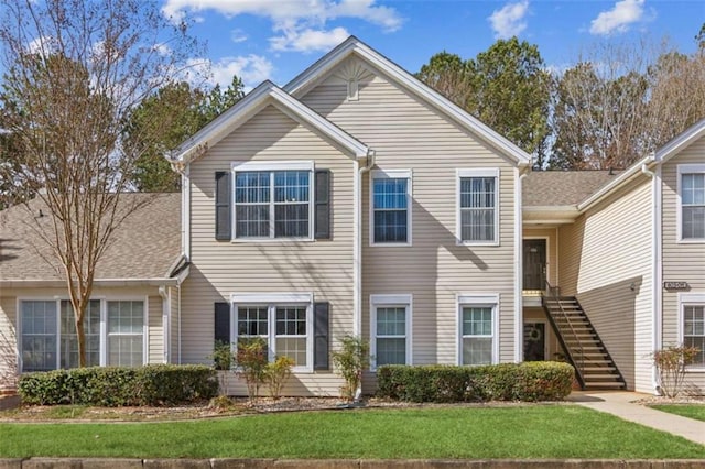 view of front of home featuring stairway and a front lawn