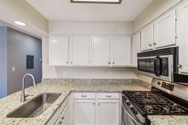 kitchen with stainless steel appliances, a sink, and white cabinets