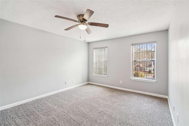 unfurnished room with carpet floors, ceiling fan, baseboards, and a textured ceiling