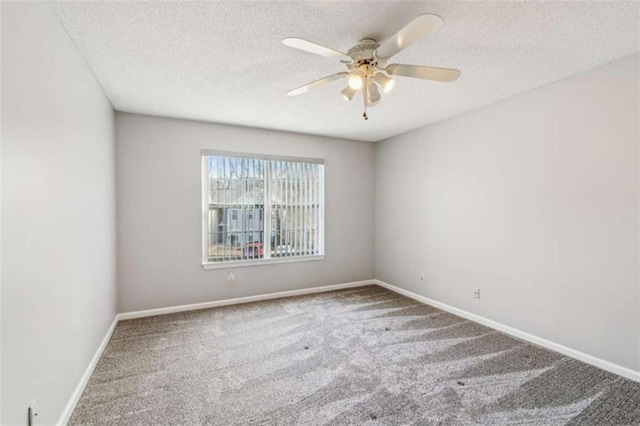 carpeted empty room with ceiling fan, a textured ceiling, and baseboards