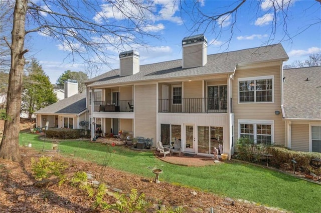 rear view of property with a chimney and a yard