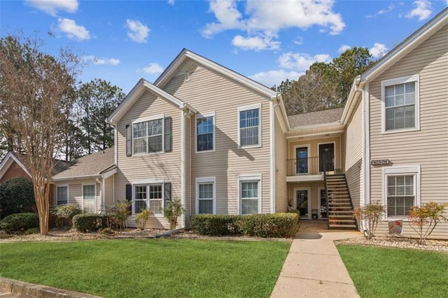 view of front of home featuring stairway and a front lawn