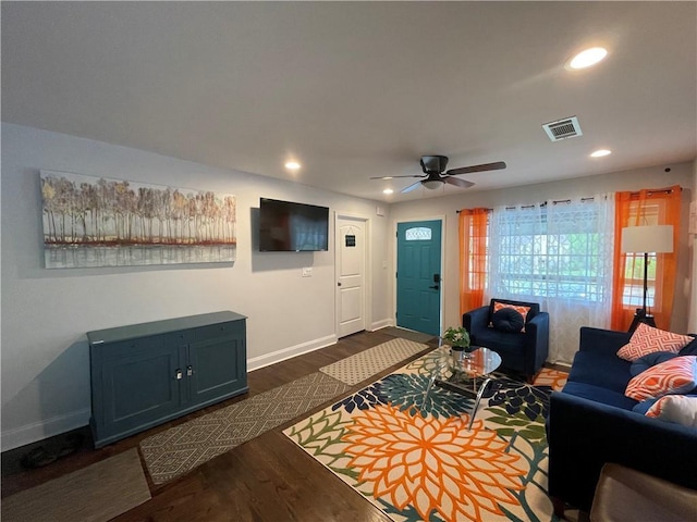 living area featuring baseboards, visible vents, dark wood-style flooring, and recessed lighting