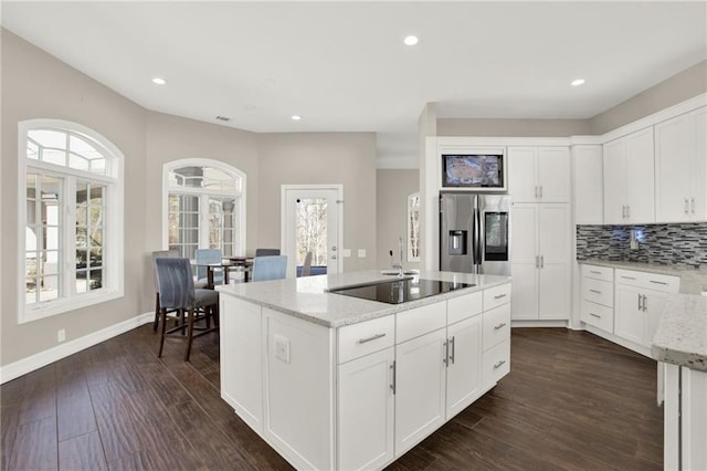 2150 Fincher Rd, Canton, GA 30114 - kitchen with stainless steel fridge with ice dispenser, black electric cooktop, a center island with sink, dark wood-type flooring, and light stone counters