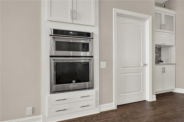 2150 Fincher Rd, Canton, GA 30114 - kitchen featuring glass insert cabinets, baseboards, double oven, white cabinetry, and dark wood-type flooring