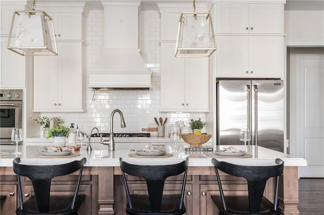 kitchen featuring white cabinets, decorative backsplash, dark hardwood / wood-style flooring, custom range hood, and stainless steel appliances