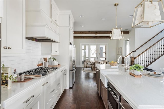 kitchen with hanging light fixtures, stainless steel appliances, dark hardwood / wood-style flooring, decorative backsplash, and white cabinets