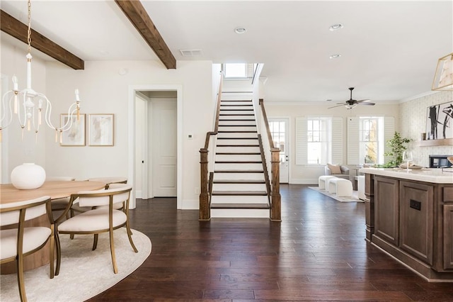 dining space with ceiling fan, beam ceiling, and dark hardwood / wood-style flooring