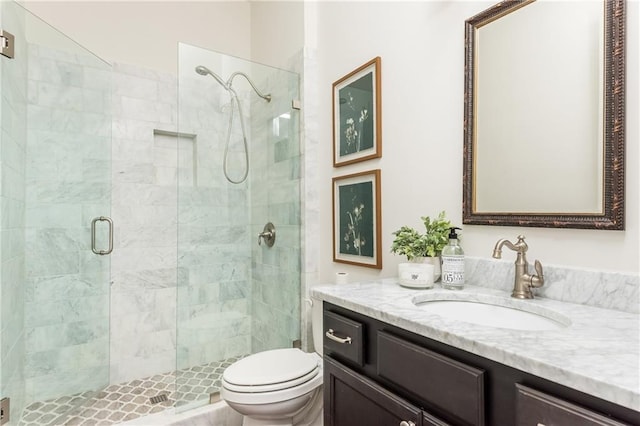 bathroom featuring an enclosed shower, vanity, and toilet