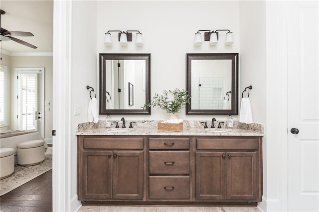 bathroom with wood-type flooring, vanity, ceiling fan, and ornamental molding